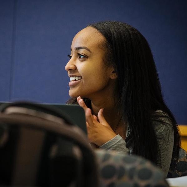 Asian studies student listening and smiling in class.